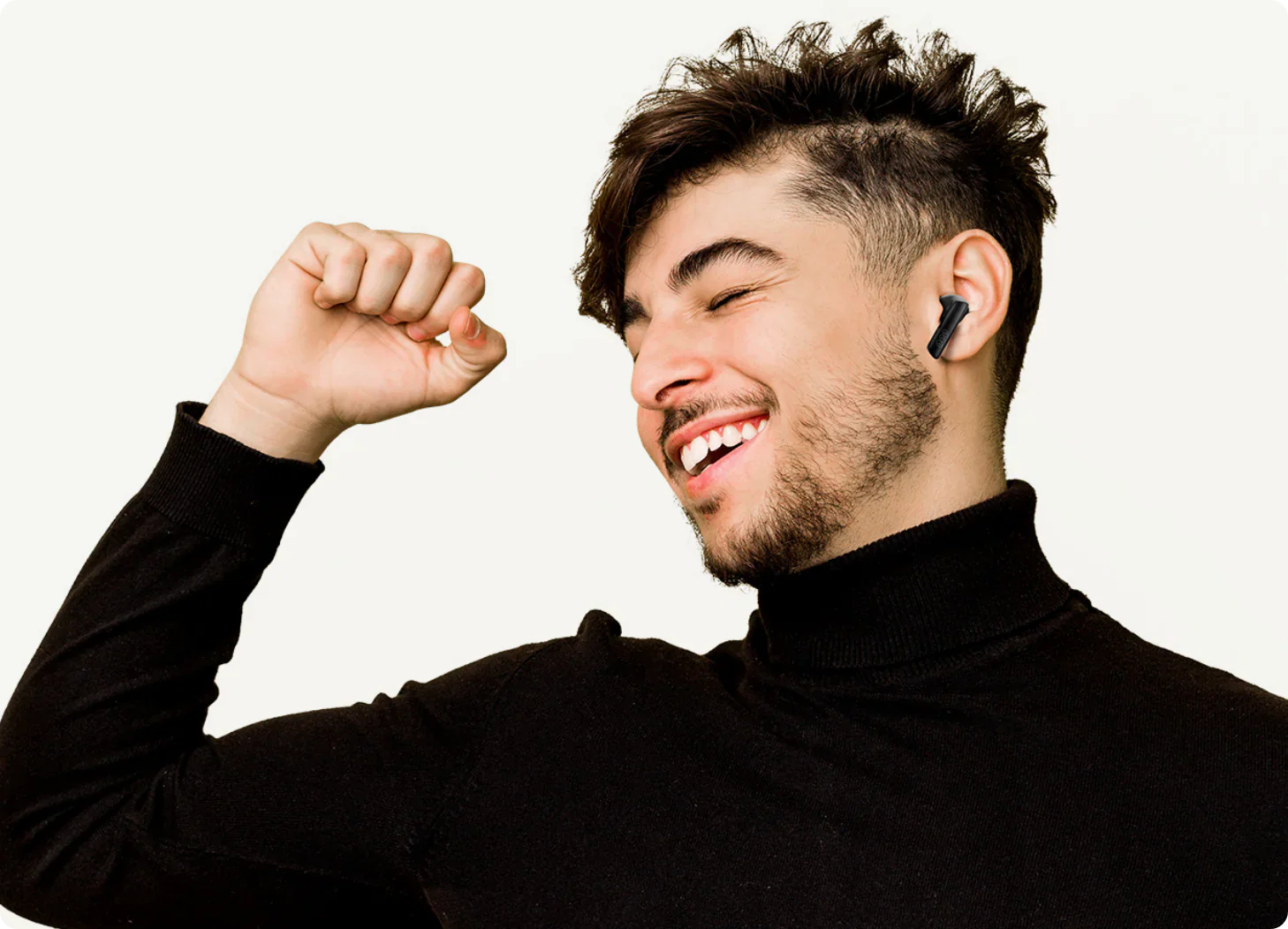 Homem sorrindo com fone de ouvido sem fio preto, celebrando música. Ideal para e-commerce de áudio premium.