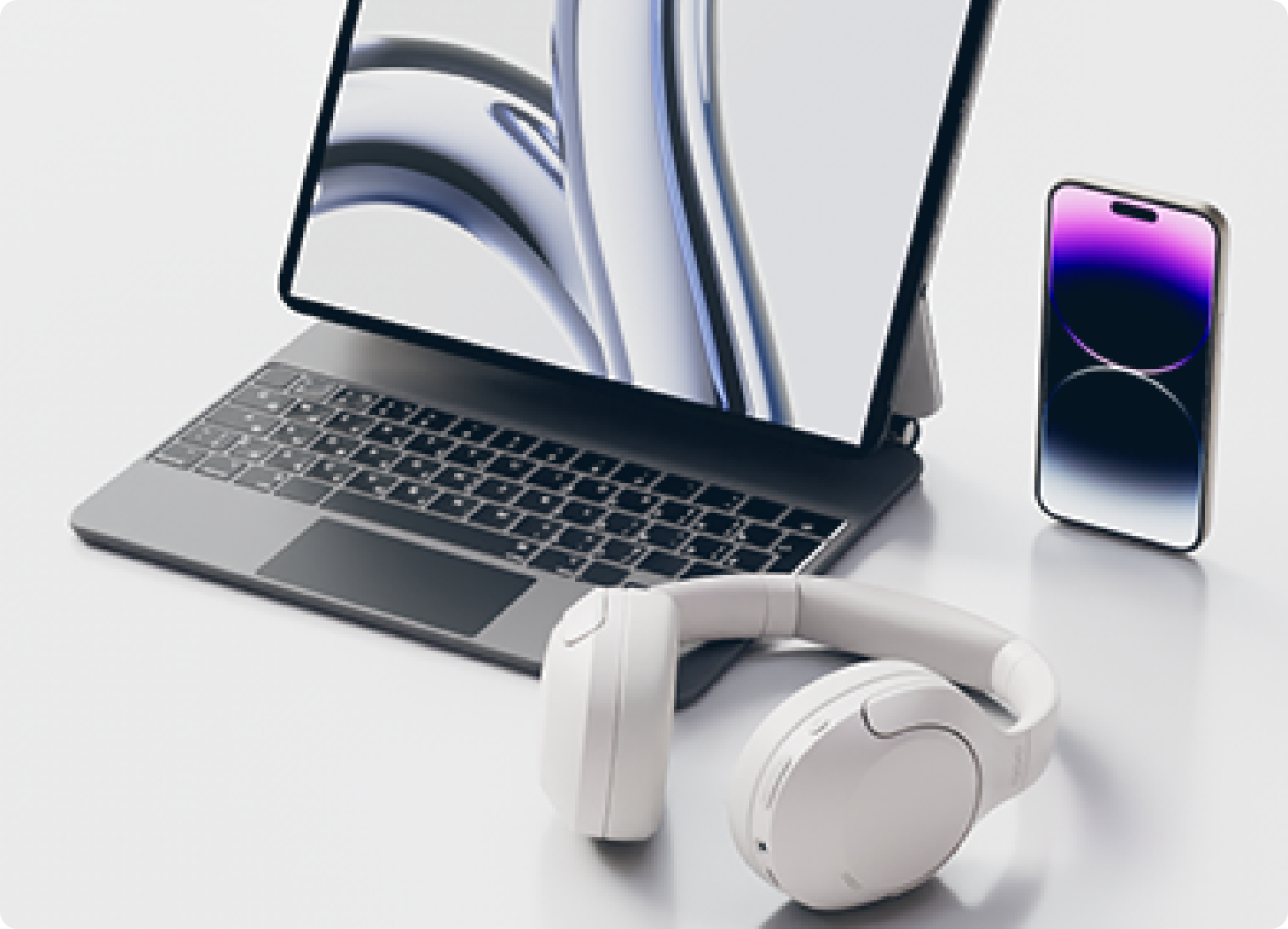 Laptop, smartphone e fones de ouvido brancos em fundo claro. Tecnologia moderna para trabalho e entretenimento.