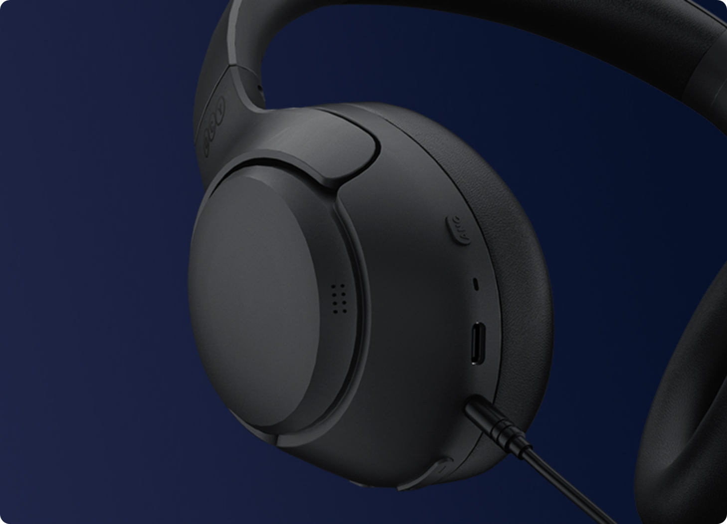 Fone de ouvido preto com fio USB-C e controles no earcup, fundo azul escuro.